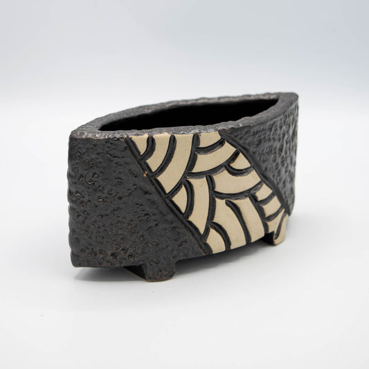 Ceramic container with textured surface and patterned interior on a white background