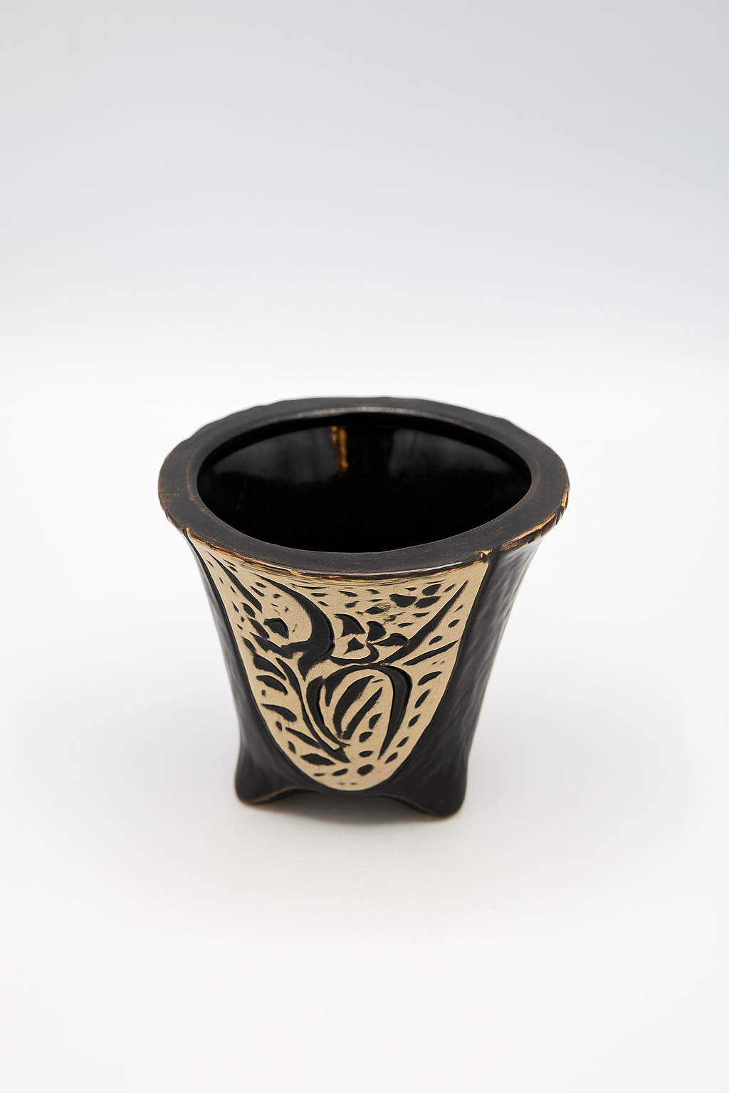Black ceramic vase with gold decorative patterns on a white background