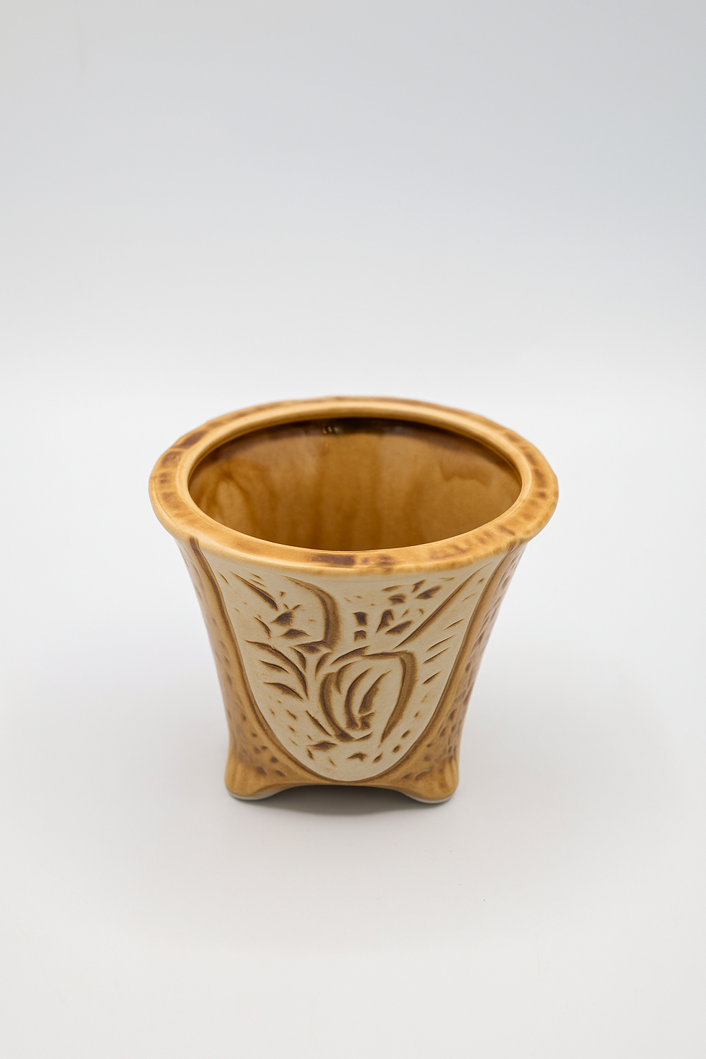 Ceramic planter with decorative patterns on a white background