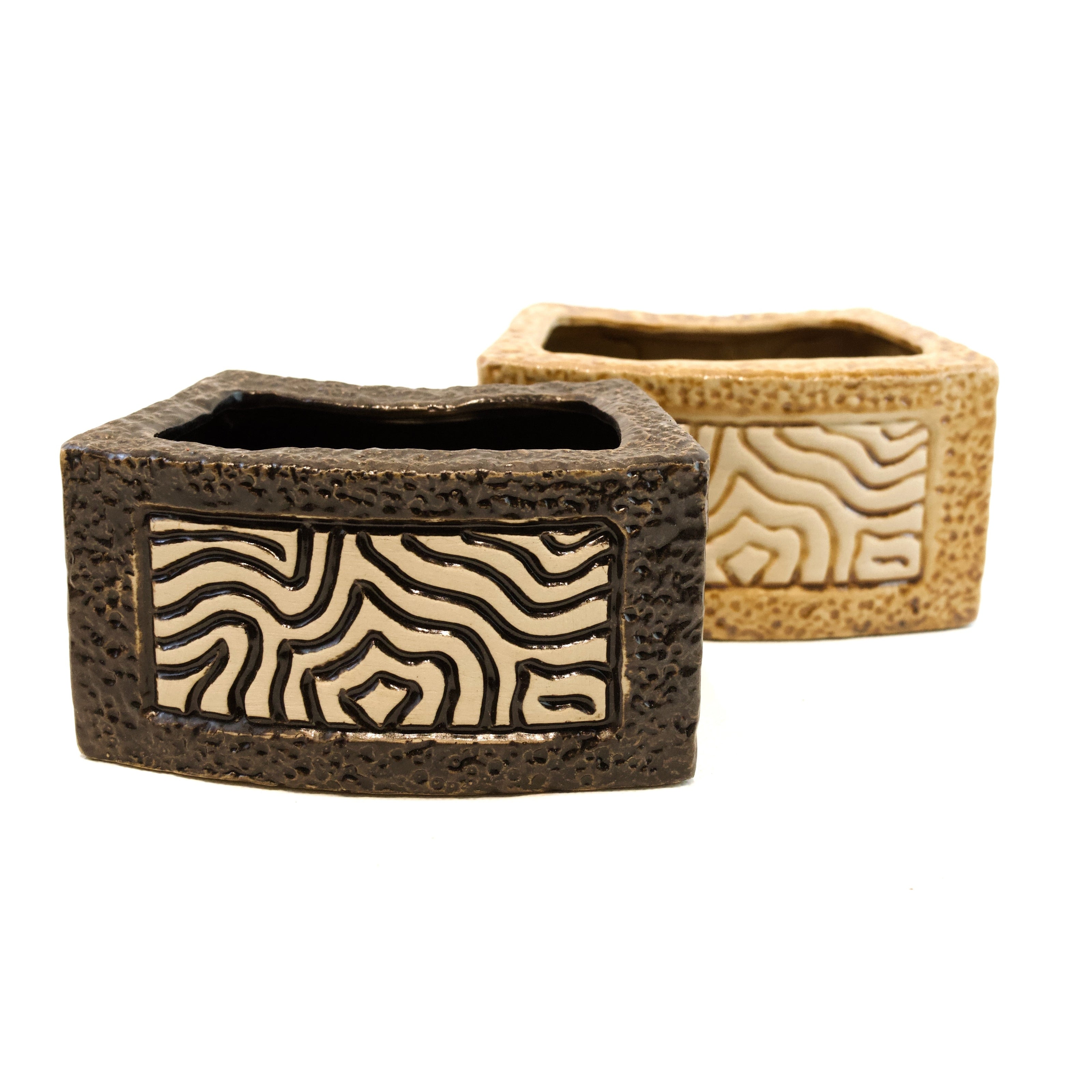 Two woven rectangular containers with zebra pattern on a white background