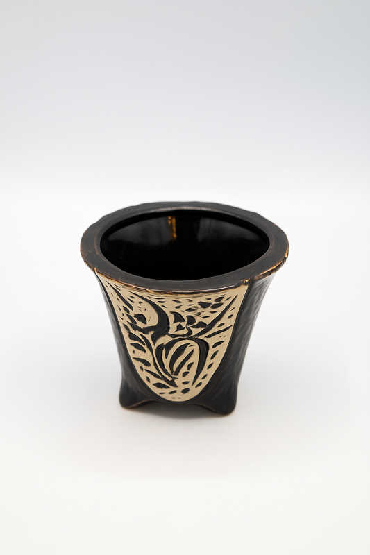 Black ceramic vase with gold decorative patterns on a white background