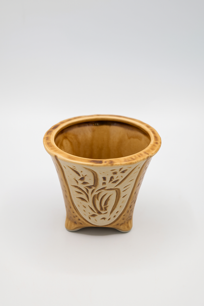 Ceramic planter with decorative patterns on a white background