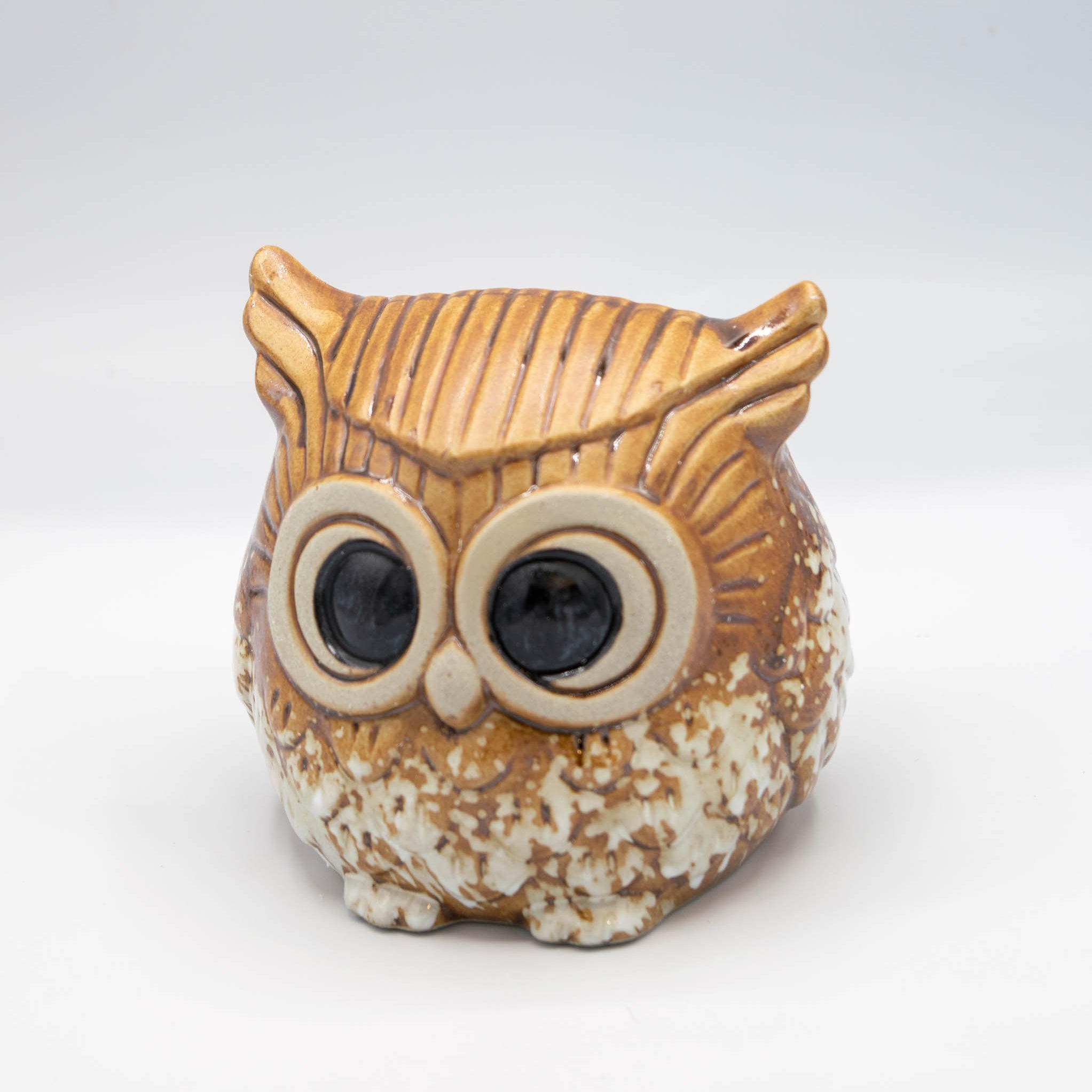 Ceramic owl-shaped container on a white background